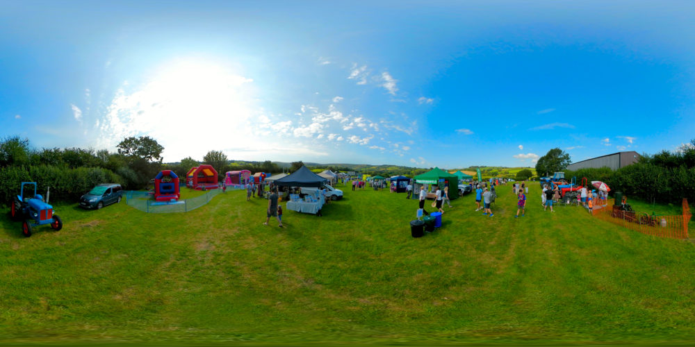 a group of people standing on top of a lush green field .