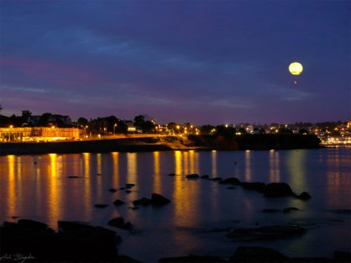 A balloon over a body of water at night
