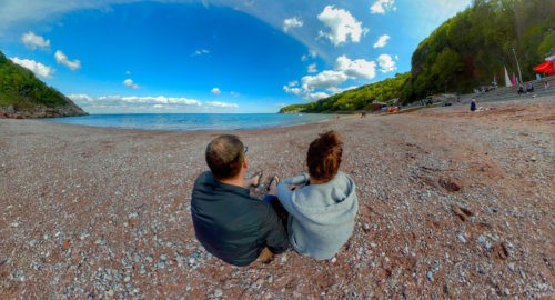 two people sat on a beach